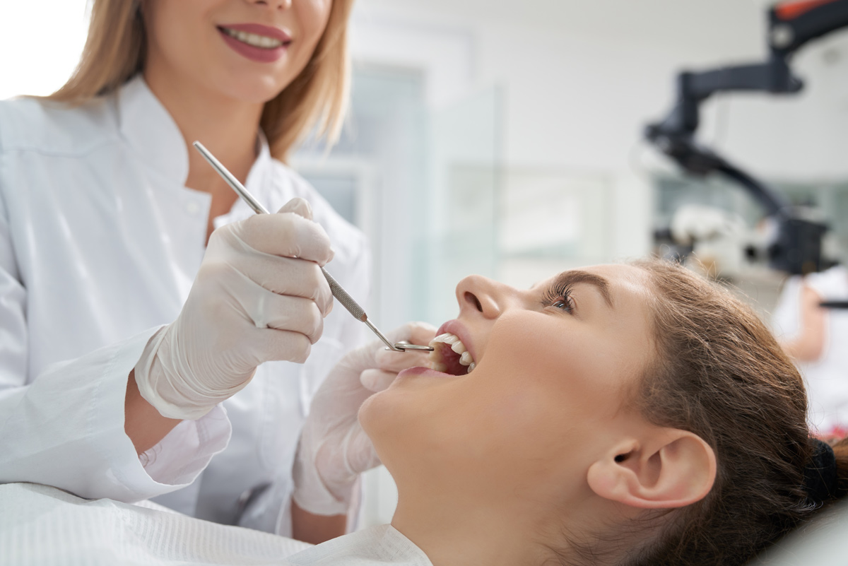 Girl getting her teeth cleaned by a dental hygienist